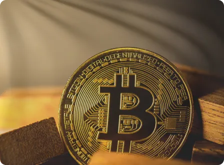 Gold Bitcoin coin on wooden surface with warm lighting