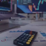 Forex trading workspace with calculator, charts, and candlestick graphs on screens