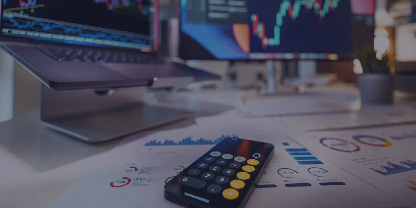 Forex trading workspace with calculator, charts, and candlestick graphs on screens
