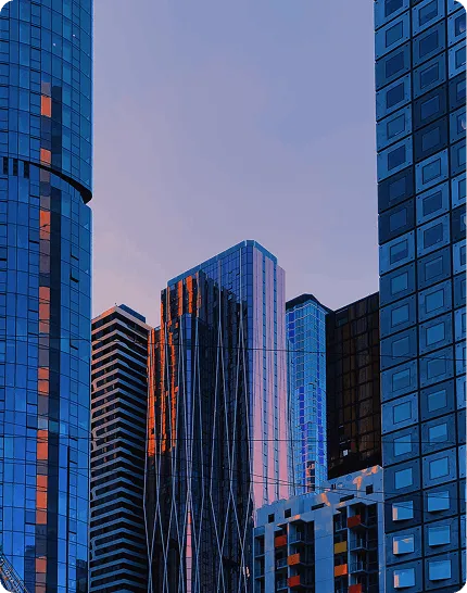 Modern skyscrapers with blue glass facades and sunset lighting